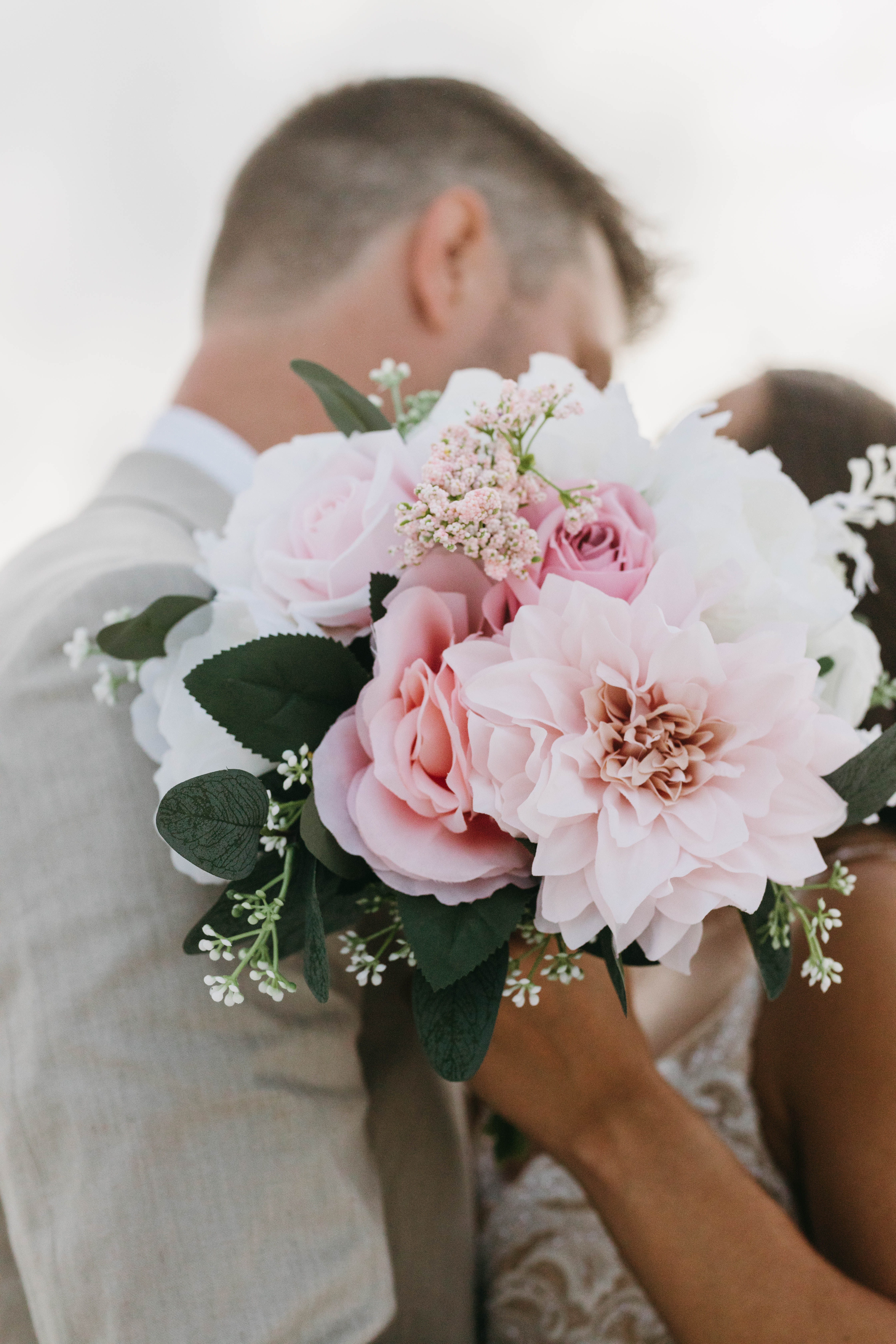 Bride and groom sharing romantic moment on beach with ocean waves in background